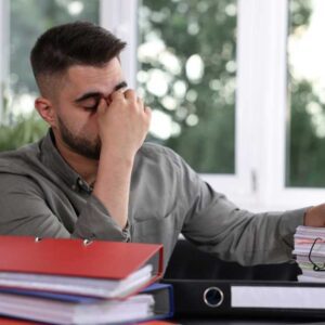 Homeowner reviewing paperwork with visible stress during a delayed home sale in the Atlanta market