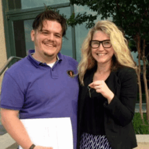 Couple standing in front of their home after selling their house