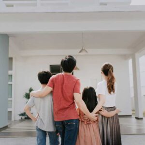 A family from Orlando standing together outside their home with arms around each other, symbolizing stability, togetherness, and a new chapter.