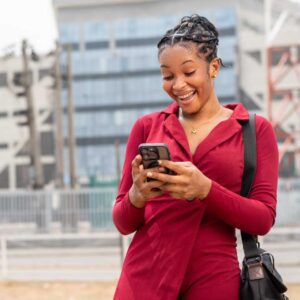 Homeowner smiling while checking her phone after receiving a home value estimate by text